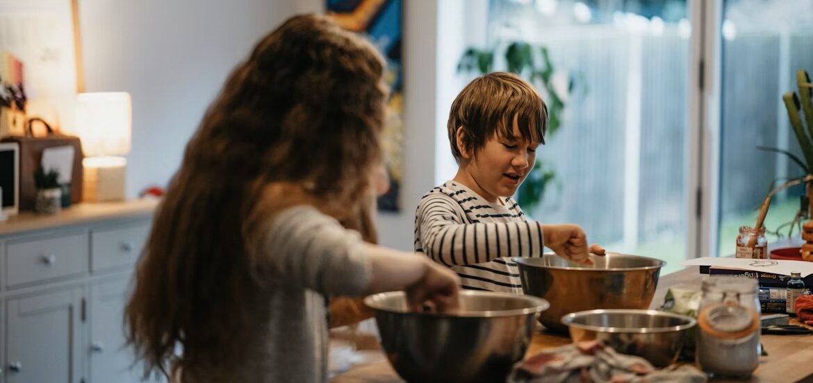 2 children, 1 boy and 1 girl, in a kitchen using a mixing bowl each