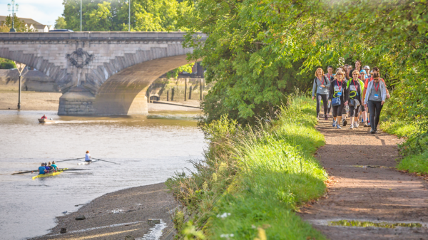 Collection of walkers on the walking next to the Thames on a sunny day