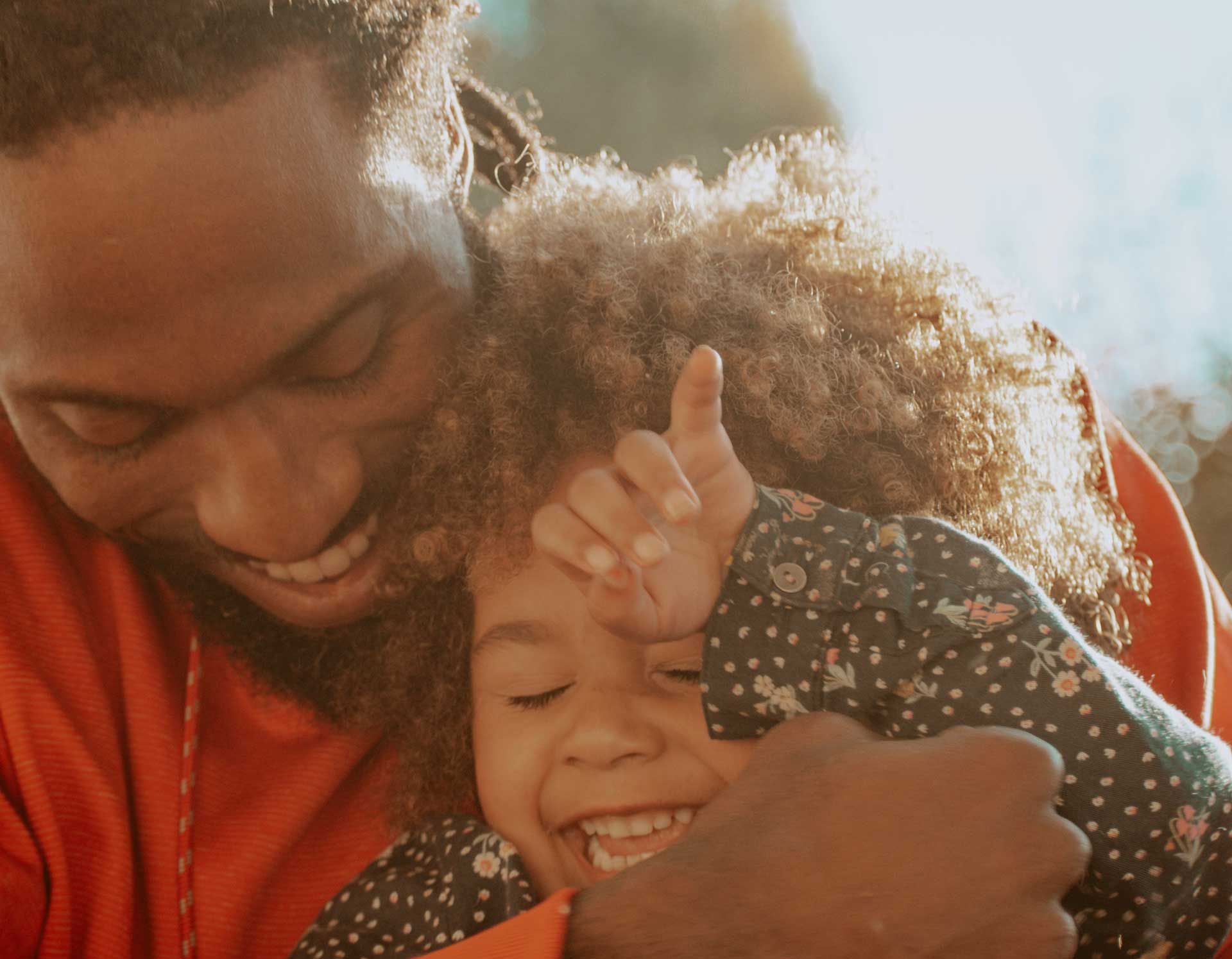 Close up for smiling man embracing small child