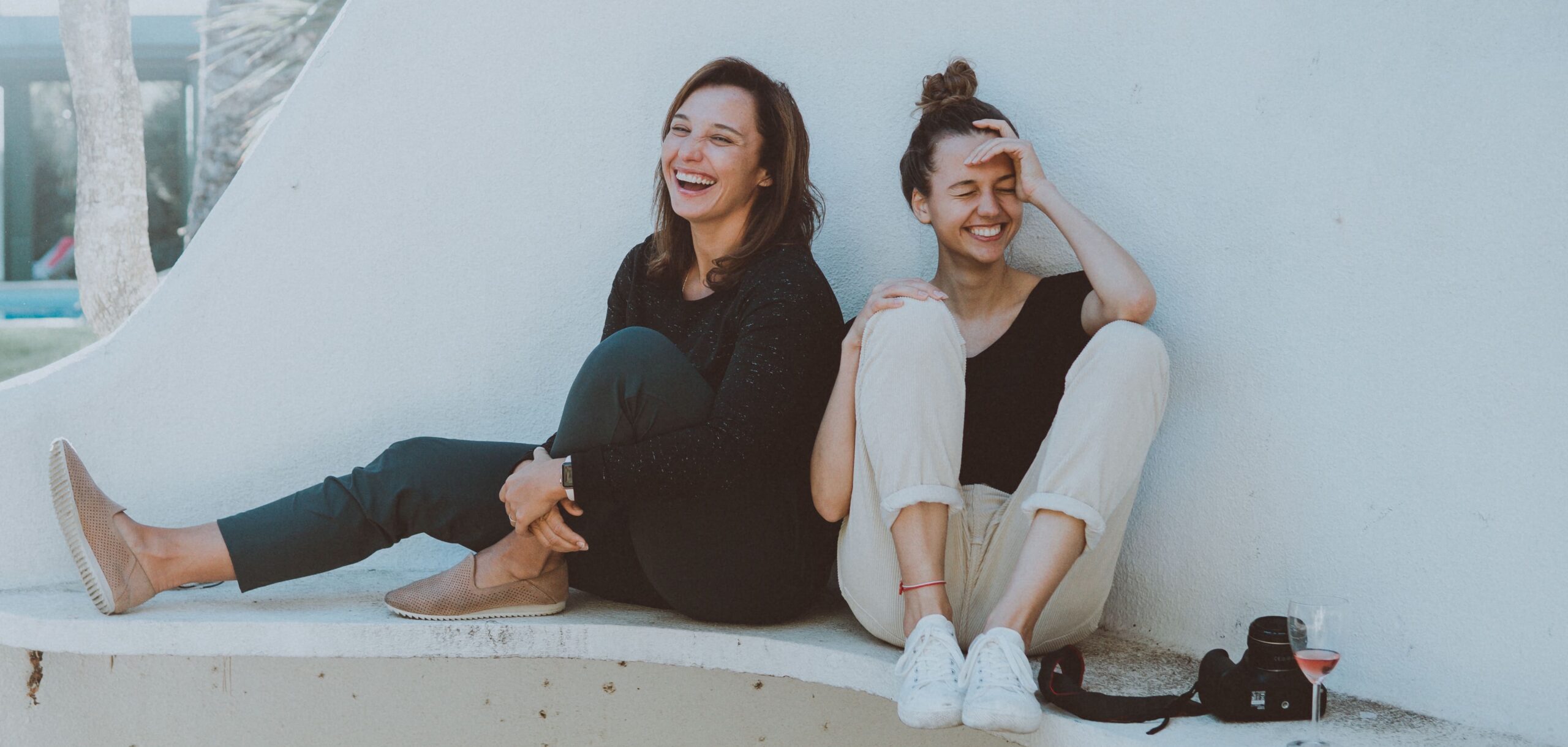 two women sitting together and laughing