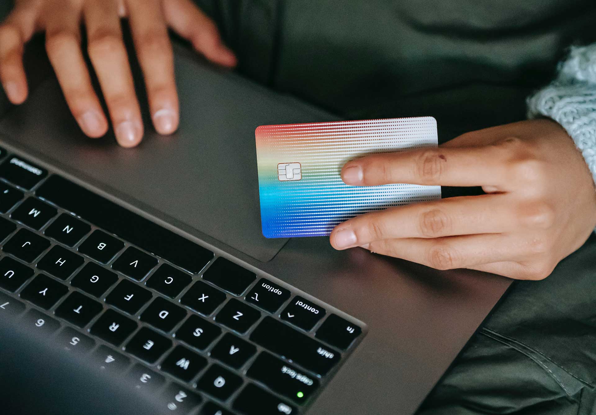 Hand holding a rainbow credit card