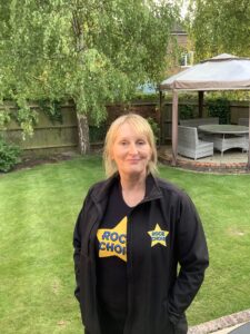 Jude stood outside with black 'Rock Choir' t-shirt and jacket