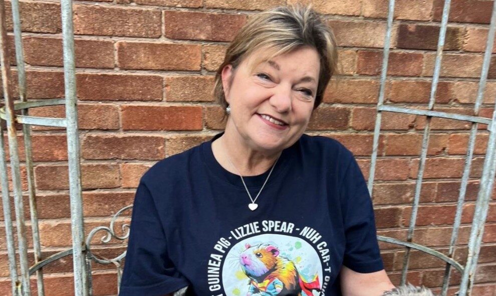 Lizzie Spear-sat outside with a small dog on her lap