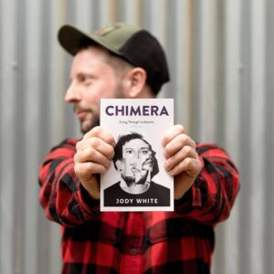 Jody holding up his book in paperback called 'Chimera'