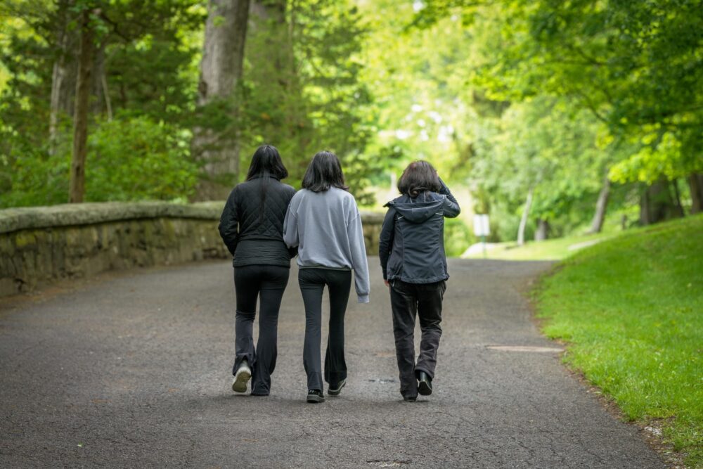three people walking in nature
