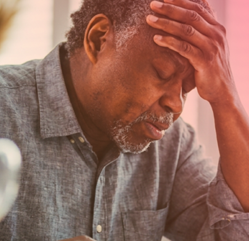 Older man with head in his hands and eyes closed